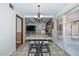 Open dining area featuring a modern light fixture, a sliding glass door, and a view into the living room at 7645 W Bluefield Ave, Glendale, AZ 85308