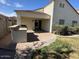 This backyard has a covered patio, built-in grill, grass, and a stone-paved area at 12041 W Carlota Ln, Sun City, AZ 85373