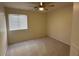 Bedroom with neutral carpeting and a window with blinds, complemented by a ceiling fan at 12041 W Carlota Ln, Sun City, AZ 85373