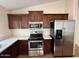 Kitchen with stainless steel appliances, dark wood cabinets, and white countertops at 12041 W Carlota Ln, Sun City, AZ 85373