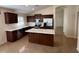 A stunning kitchen featuring dark wood cabinets, stainless steel appliances, and a center island at 12041 W Carlota Ln, Sun City, AZ 85373