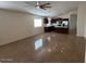 Open floor plan, connecting living room and kitchen, featuring tile floors and natural light at 12041 W Carlota Ln, Sun City, AZ 85373