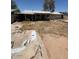 View of overgrown backyard with open pit and rear of home at 18415 N 33Rd Ave, Phoenix, AZ 85053