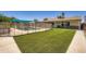 Inviting backyard showcasing a pool with a safety fence and an expansive green lawn at 2164 E Jerome Ave, Mesa, AZ 85204