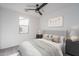A modern bedroom with neutral gray carpet, a window for natural light, with staged bed and furniture at 2732 N 217Th Ave, Buckeye, AZ 85396