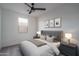 A modern bedroom with neutral gray carpet, a window for natural light, with staged bed and furniture at 2732 N 217Th Ave, Buckeye, AZ 85396