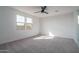 Bright, spacious bedroom with neutral carpet, a ceiling fan, and ample natural light at 2732 N 217Th Ave, Buckeye, AZ 85396