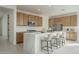 Bright modern kitchen with a central island and chairs at 2732 N 217Th Ave, Buckeye, AZ 85396
