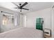This bedroom features a ceiling fan, window, and a unique, green safe with a neutral colored bedspread at 4065 E University Dr # 76, Mesa, AZ 85205