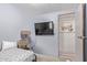 A simple bedroom features a TV, a cat tree, and an open doorway that leads to another room at 4065 E University Dr # 76, Mesa, AZ 85205