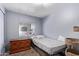 A modest bedroom is shown with a single bed, a dresser, and a window to let in natural light at 4065 E University Dr # 76, Mesa, AZ 85205