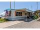 Inviting manufactured home with a spacious carport, covered patio, and low-maintenance gravel landscaping at 4065 E University Dr # 76, Mesa, AZ 85205