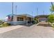 Inviting manufactured home with a spacious carport, covered patio, and low-maintenance gravel landscaping at 4065 E University Dr # 76, Mesa, AZ 85205