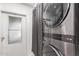 A modern laundry room features a stacked washer and dryer set next to a door with window at 4065 E University Dr # 76, Mesa, AZ 85205