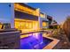 The backyard pool reflects the light from the home's interior at dusk at 4544 N Evans Dr, Scottsdale, AZ 85251