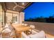 A covered balcony with dining table and seating offers views of the landscaped yard at 4544 N Evans Dr, Scottsdale, AZ 85251