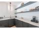 Modern wet bar featuring sleek cabinetry, light countertops, stylish shelving, and beverage center at 4544 N Evans Dr, Scottsdale, AZ 85251