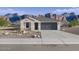 Charming single-story home with a two-car garage and desert landscaping against a backdrop of mountains at 12599 W Mountain View Dr, Avondale, AZ 85323