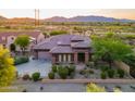 Overhead shot of a desert home with a tile roof, lush desert plants, and mountain views at 12797 S 179Th Dr, Goodyear, AZ 85338