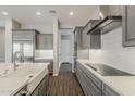 Modern kitchen boasts gray cabinetry, quartz countertops, stainless steel appliances, and wood-look flooring at 578 E Las Puertas Ln, Queen Creek, AZ 85140