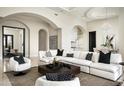Open-concept living room features an arched entryway, modern furniture, and tile floors at 6112 E Quartz Mountain Rd, Paradise Valley, AZ 85253