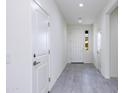 Bright hallway featuring neutral paint, gray tile flooring, and access to various rooms at 17463 N 66Th Ave, Glendale, AZ 85308