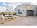 Modern desert home with stone facade, black garage door, and professional landscaping at 12297 E Troon Vista Dr # 255, Scottsdale, AZ 85255