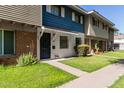 Inviting townhome displaying a neat front lawn with a walkway that leads to the black front door at 1673 W Hazelwood St, Phoenix, AZ 85015