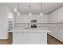 Modern kitchen boasts white cabinets, stainless steel appliances, and a large center island at 18795 E Elizar Dr, Gold Canyon, AZ 85118