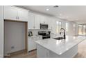 Bright, open kitchen featuring white cabinetry, stainless steel appliances, and an island with a breakfast bar at 18507 E Camila Dr, Gold Canyon, AZ 85118