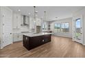 Modern kitchen featuring white cabinets, a dark island, stainless steel appliances, and stylish pendant lighting at 4315 S 123Rd Ave, Avondale, AZ 85323