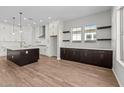 Beautiful kitchen boasts sleek white cabinetry, a contrasting dark island, stainless steel appliances, and designer lighting at 4315 S 123Rd Ave, Avondale, AZ 85323