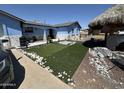 Charming blue single-story home featuring newly installed artificial grass and rock details at 5007 W Weldon Ave, Phoenix, AZ 85031