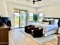 Spacious main bedroom with a fireplace, balcony access, neutral tones, and elegant furnishings at 24724 N 119Th Pl, Scottsdale, AZ 85255