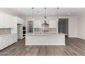 Open concept kitchen with white cabinets, island, and stainless steel appliances at 16400 W Avenida Del Sol --, Surprise, AZ 85387