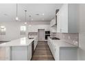 White kitchen with an island, stainless steel appliances, and white subway tile at 16400 W Avenida Del Sol --, Surprise, AZ 85387