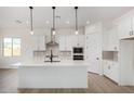 Modern kitchen with white cabinets, quartz countertops, and stainless steel appliances at 16412 W Avenida Del Sol --, Surprise, AZ 85387