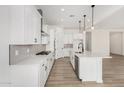 Modern kitchen with white cabinets, island, and stainless steel appliances at 16412 W Avenida Del Sol --, Surprise, AZ 85387