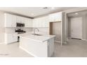 White kitchen with island, stainless steel appliances, and white cabinets at 40347 W Wade Dr, Maricopa, AZ 85138