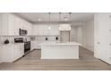 Bright white kitchen boasts an island, stainless steel appliances, and modern pendant lighting at 18812 E Elizar Dr, Gold Canyon, AZ 85118