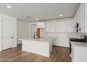 Modern kitchen with white cabinets, island, and stainless steel appliances at 40461 W Wade Dr, Maricopa, AZ 85138