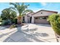Front view of a house with a large palm tree and two-car garage at 29110 N 129Th Ave, Peoria, AZ 85383