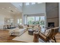 Sun-filled living room featuring hardwood floors, a stone fireplace, and large sliding doors with great backyard views at 3965 E Sierra Vista Dr, Paradise Valley, AZ 85253