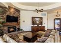 Warm living room with a stone fireplace, rich wood accents, and ample seating at 10537 N Crestview Dr, Fountain Hills, AZ 85268