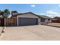 View of the garage and side gate, highlighting the driveway and exterior features at 4729 W Orangewood Ave, Glendale, AZ 85301