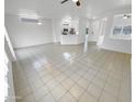 Spacious living room with tile flooring, all-white walls, and views into other rooms at 16186 W Silver Falls Dr, Surprise, AZ 85374