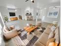Bright living room featuring tile flooring, plush seating, and a view of the adjacent kitchen at 16186 W Silver Falls Dr, Surprise, AZ 85374