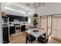 Modern kitchen featuring black cabinets, stainless steel appliances, and a marble dining table at 11322 W Diana Ave, Peoria, AZ 85345