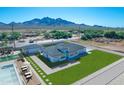 Aerial view of a house featuring a pool, basketball court, desert landscaping, and mountain views at 26761 S 181St Pl, Queen Creek, AZ 85142