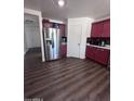 Kitchen features stainless steel refrigerator and red cabinets at 6245 W Southgate St, Phoenix, AZ 85043